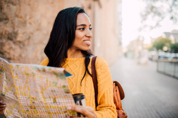 istock Cheerful female tourist holding map and looking around 1159424553