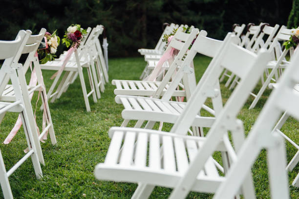 istock Outgoing wedding ceremony. Decor Studio. white wooden chairs on a green lawn. 1159426850