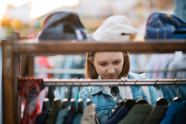 istock Young girl choosing clothes in a second hand market in summer, zero waste concept 1159428207