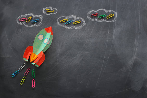 istock education. Back to school concept. rocket cut from paper and painted over blackboard background. top view, flat lay 1159428347