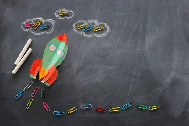 istock education. Back to school concept. rocket cut from paper and painted over blackboard background. top view, flat lay 1159428349