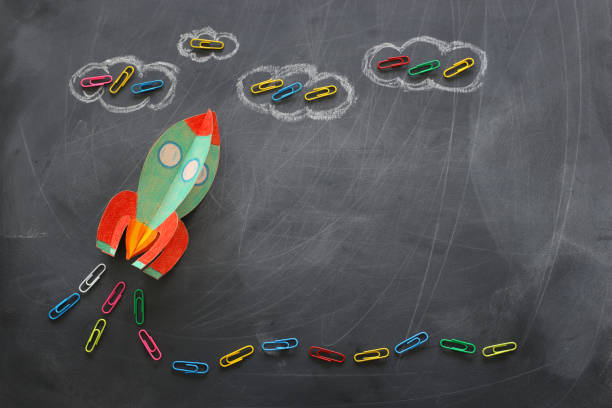 istock education. Back to school concept. rocket cut from paper and painted over blackboard background. top view, flat lay 1159428351