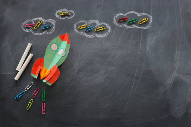 istock education. Back to school concept. rocket cut from paper and painted over blackboard background. top view, flat lay 1159428352