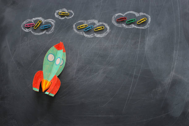 istock education. Back to school concept. rocket cut from paper and painted over blackboard background. top view, flat lay 1159428353