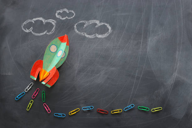 istock education. Back to school concept. rocket cut from paper and painted over blackboard background. top view, flat lay 1159428356