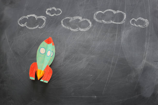 istock education. Back to school concept. rocket cut from paper and painted over blackboard background. top view, flat lay 1159428357