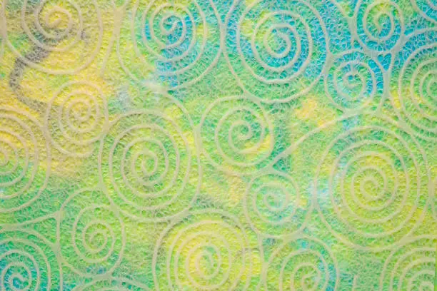 Japanese Washi tissue with white spiral pattern against marbled mulberry paper