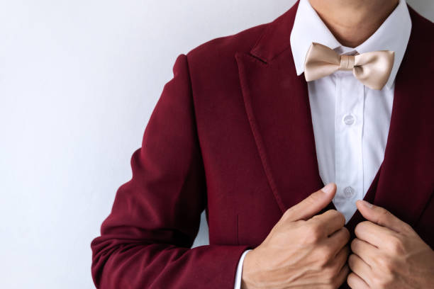 istock Young man wearing red suit with bow tie 1159430478