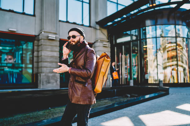 istock Trendy male traveller calling to operator for consultancy about communication in roaming during walking on city streets, caucasian hipster guy making international telephone conversation with friend 1159430865