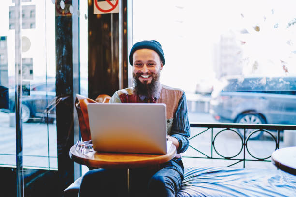 istock Cheerful hipster guy watching funny videos in social networks and laughing from jokes using 4g connection on laptop,happy smiling male teenager communicated with friends via new application on netbook 1159430882