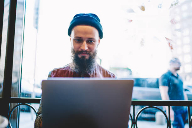 istock Positive bearded man typing application letter for asking about job vacancy on computer company, successful copywriter browsing internet and posting article on web portal using laptop device indoors 1159430887