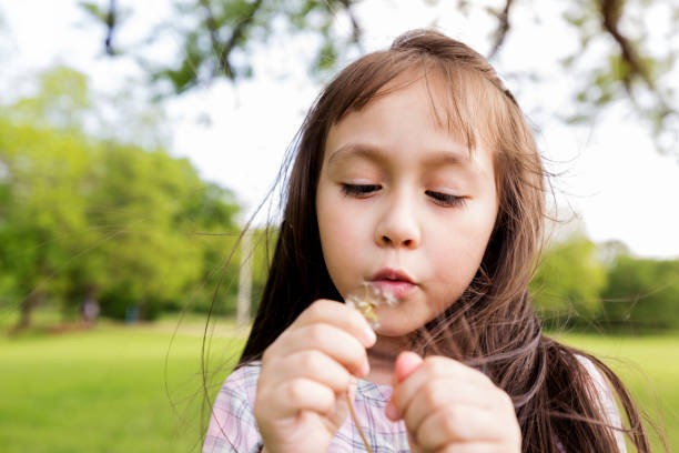 istock Little girl inspecting flower 1159431904