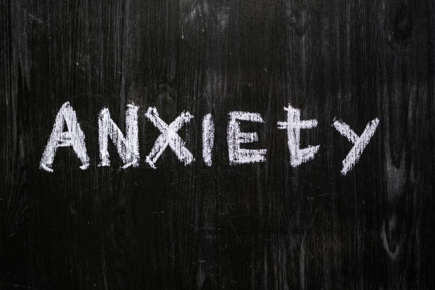 istock Anxiety word handwritten on black wood background. 1159432073
