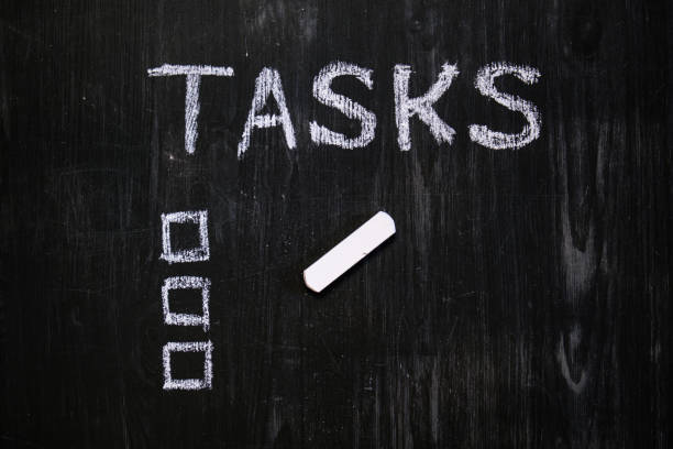 istock Tasks word handwritten with chalk on blackboard. 1159432154