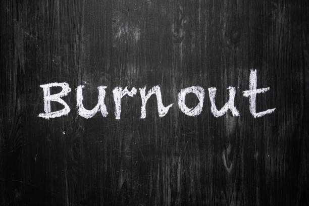 Burnout word handwritten on black wood background.