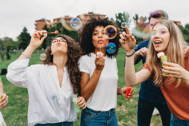 istock Friends having fun with soap bubbles together at the park 1159432172