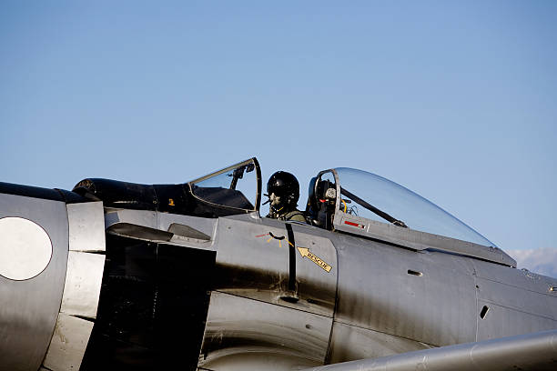 Skyraider Pilot in helmet and oxygen mask sitting in open cockpit. oxygen mask plane stock pictures, royalty-free photos & images