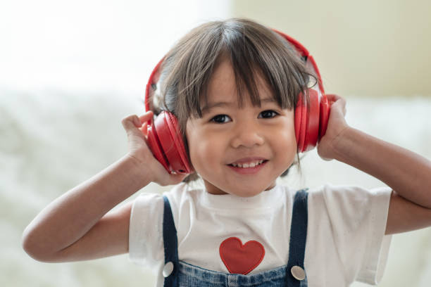 felice bambino asiatico divertiti ad ascoltare musica con le cuffie - music listening child smiling foto e immagini stock