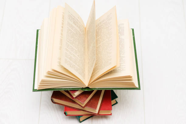 istock stack of books lies, one book is opened, with text. 1159439371