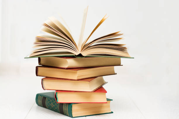 istock stack of books lies, one book is opened, with text. 1159439388