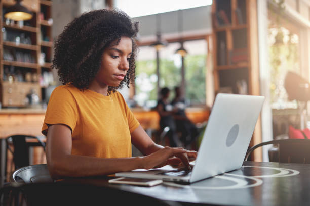 istock An african woman using laptop at coffee shop 1159439445