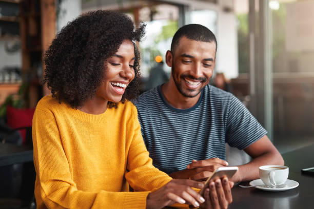istock Young couple watching video on mobile phone 1159440379