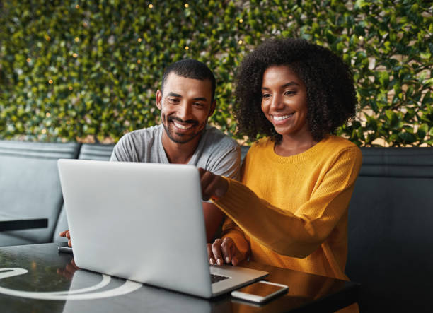 istock Young couple in cafe looking at laptop 1159440581