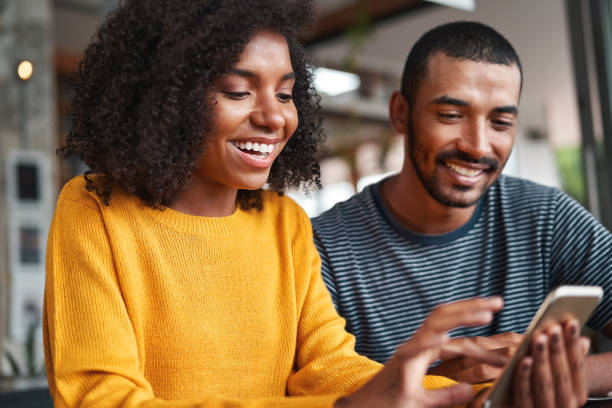 istock Cheerful young couple looking at smartphone smiling 1159440872