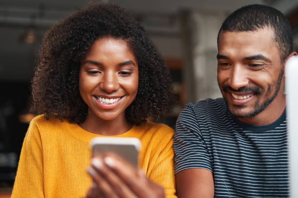 istock Smiling african couple looking at cellphone smiling 1159441463