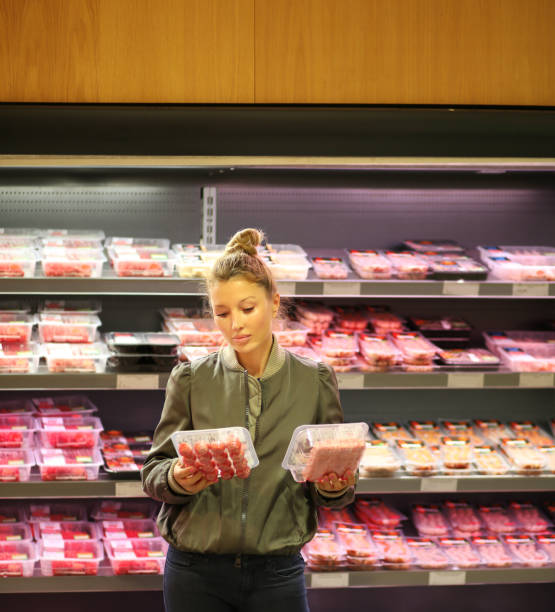 mujer comprando un paquete de carne en el supermercado - supermarket meat women packaging fotografías e imágenes de stock