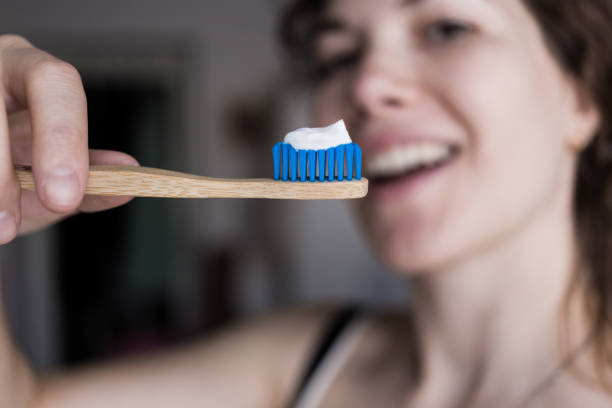 Woman holding a bamboo toothbrush with a toothpaste stock photo