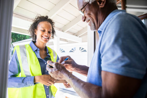 istock Young Woman Delivering Package to Senior Man 1159446012