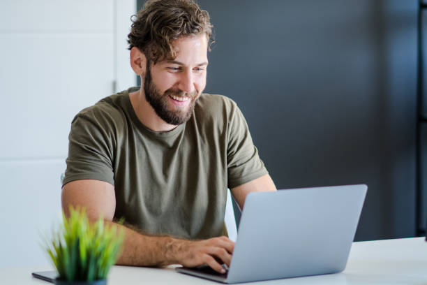 istock Happy young businessman using laptop at his office desk 1159448236