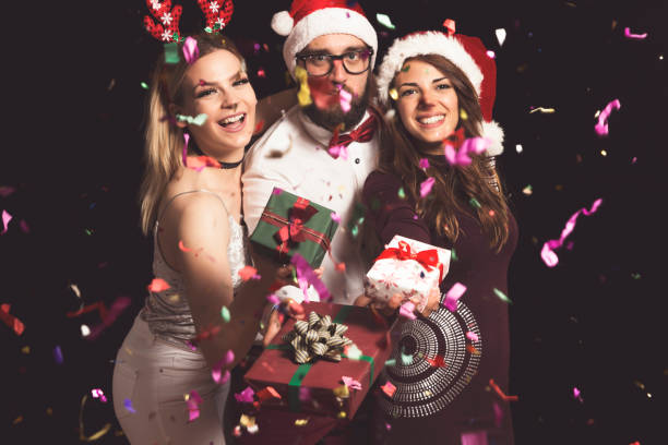 istock Friends holding Christmas presents 1159449227
