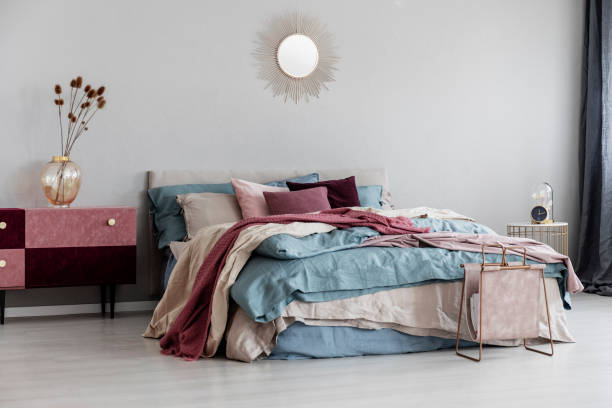 istock Sun shape like mirror on empty copy space grey wall of contemporary bedroom interior with comfortable bed 1159453886