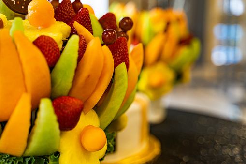 Edible Fruit basket arrangement with a variety of fruits at a party