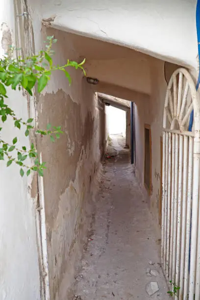 Photo of One of the charms of Mykonos, Greek island in the heart of the cyclades, are its narrow streets : white houses with small flowered balconies touching almost above paved streets