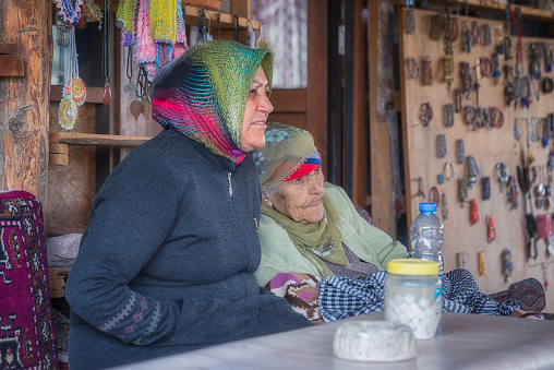 Cappadocia, Turkey - April 11, 2019: Two women sitting in a souvenir shop in the street. One of them is more than 90 years old.