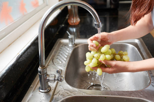 istock Woman rinsing organic grape 1159457459