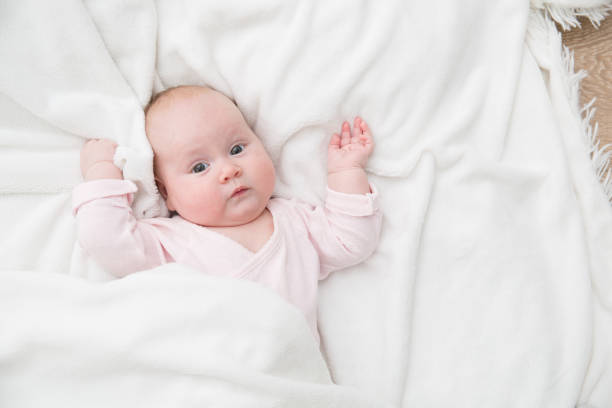istock baby girl is lying on white blanket 1159457978