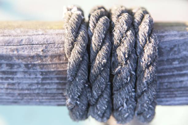 Old rope wound round a wooden pole in a marina