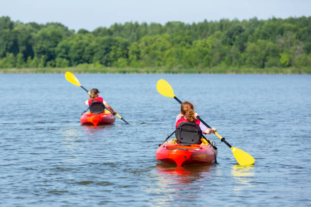 istock Two Young Girls Kayaking On Lake In Summer 1159459939