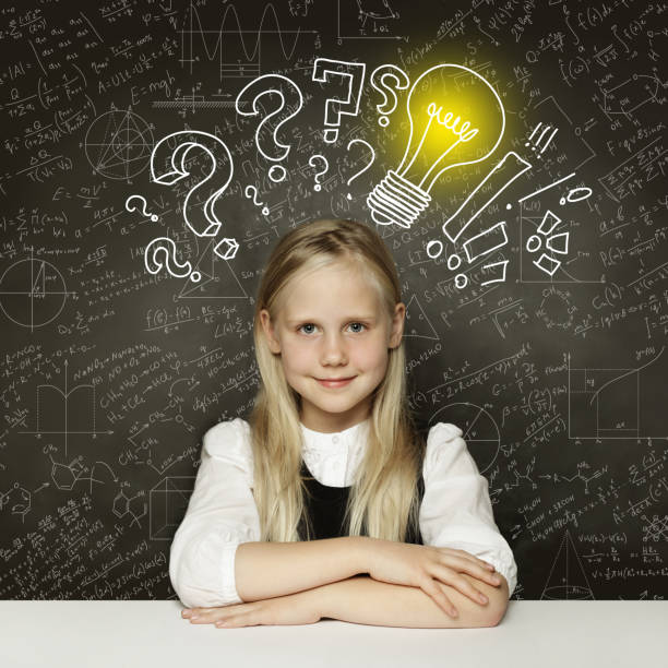 istock Idea! Smiling student girl with lightbulb on blackboard 1159461602