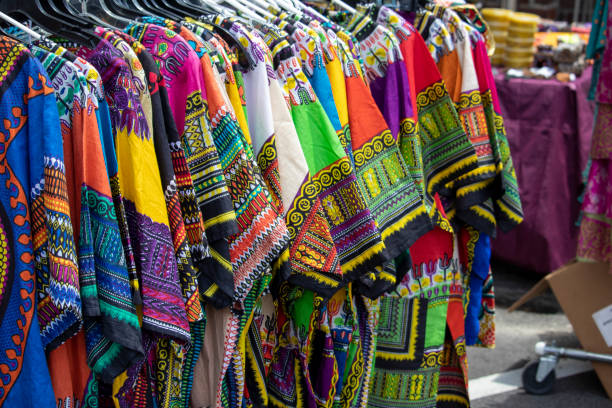 Multi-colored dashikis hang on a rack. stock photo
