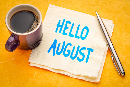 Hello August - handwriting on a napkin with a cup of coffee