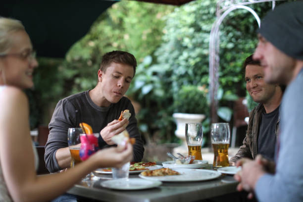 istock Friends having beers and pizza at a restaurant. 1159463085