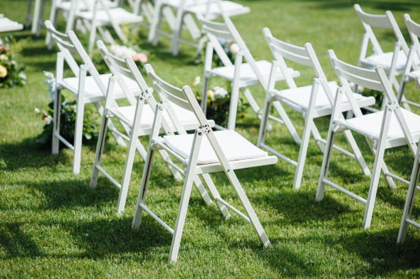 istock Outgoing wedding ceremony. Decor Studio. white wooden chairs on a green lawn. 1159464948