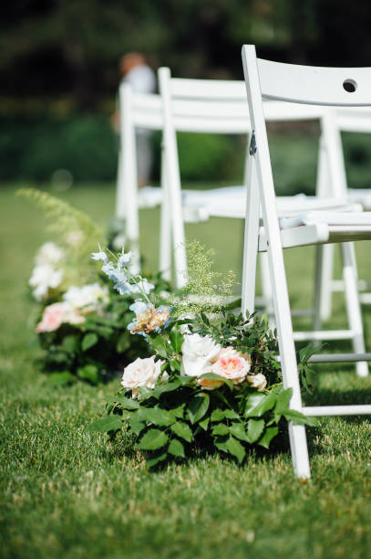 istock Outgoing wedding ceremony. Decor Studio. white wooden chairs on a green lawn. 1159465101
