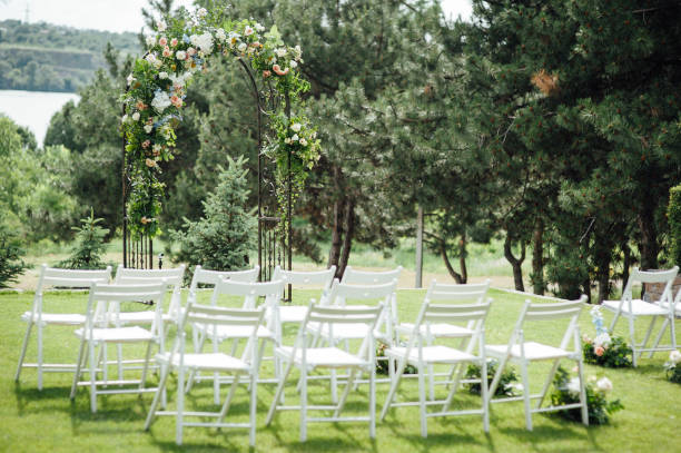 istock Outgoing wedding ceremony. Decor Studio. white wooden chairs on a green lawn. 1159465964
