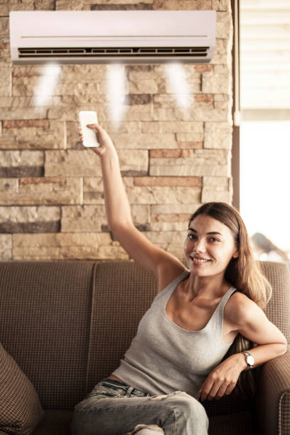 istock woman using remote control of aircondition 1159469214